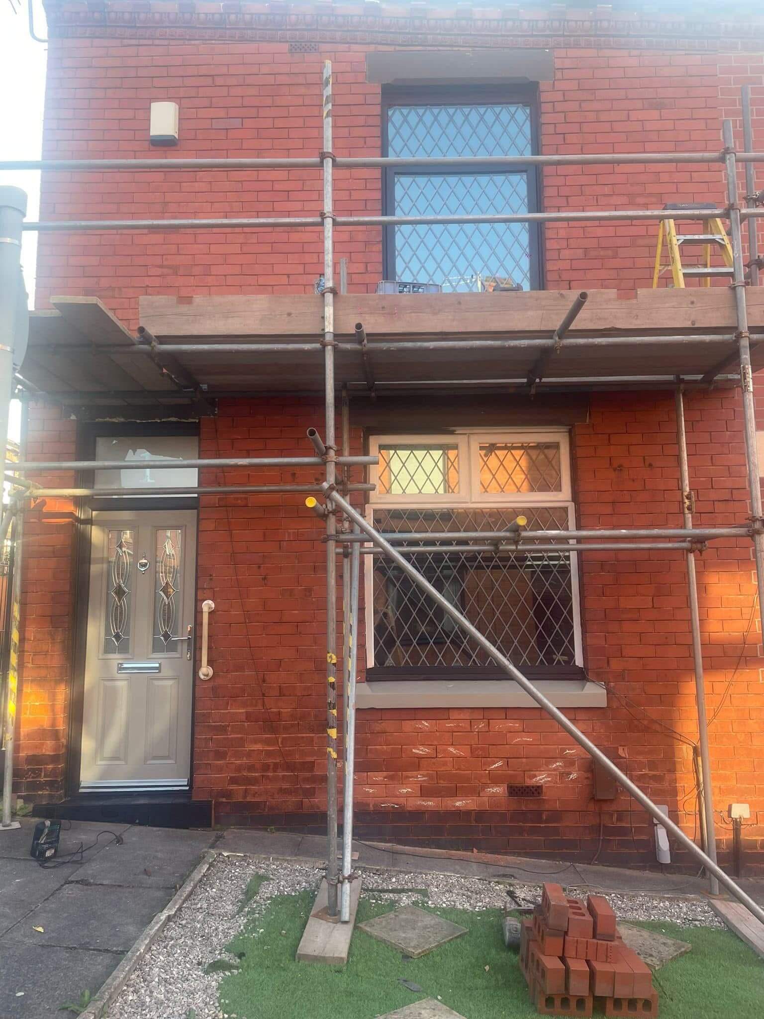 Before red brick terraced house showing worn pointing before restoration work begins