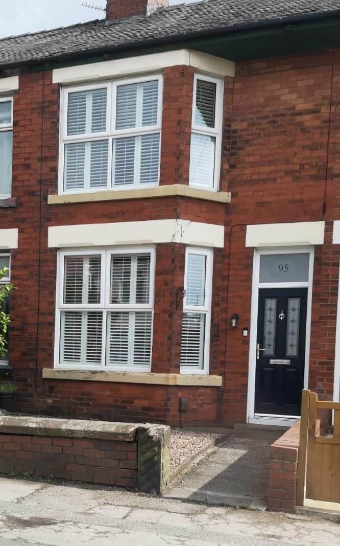 Brick house exterior showing weathered mortar joints and deteriorated pointing before professional repointing work